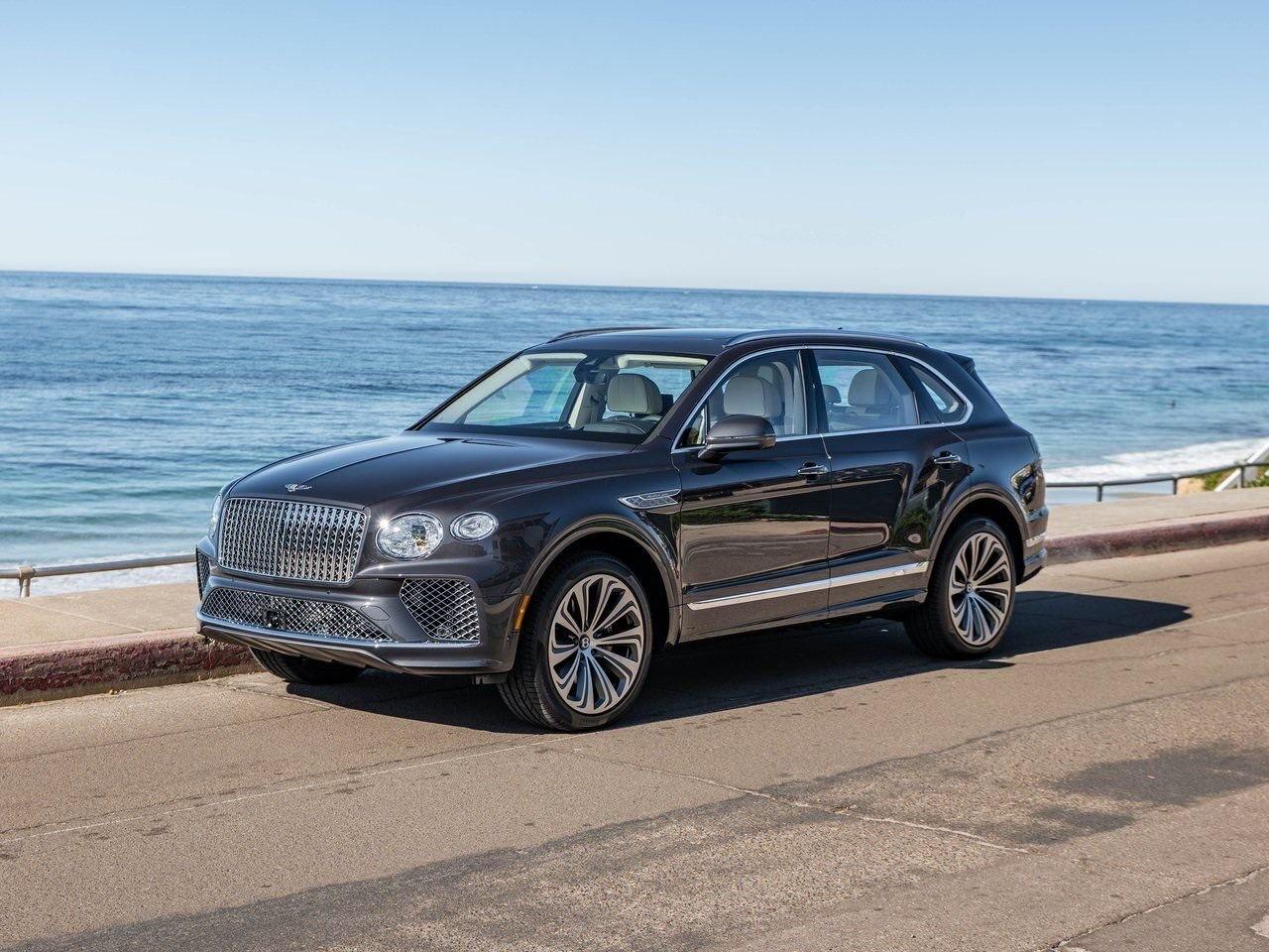 Bentley Bentayga grise, trois quarts avant en bord de mer