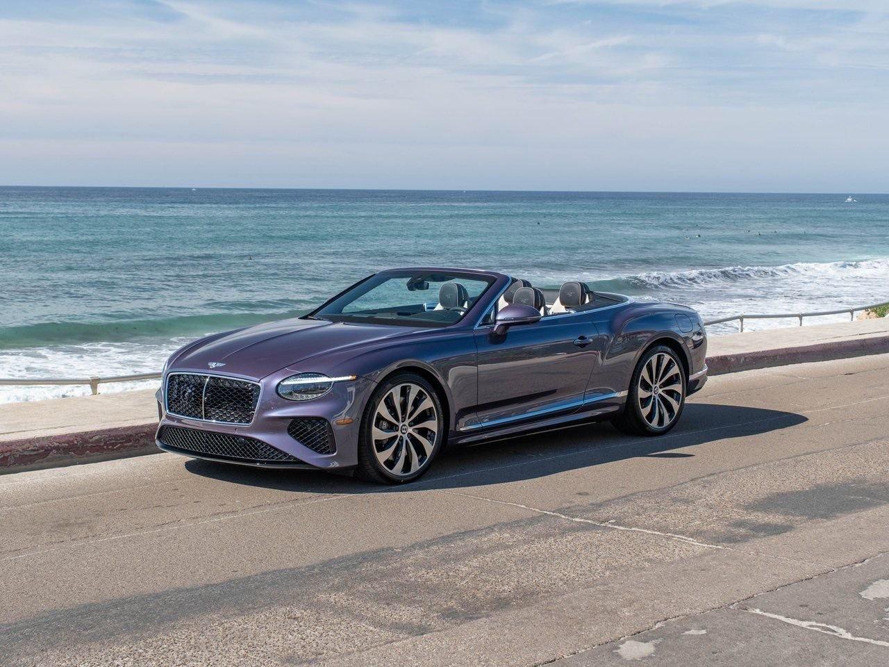 Bentley Continental GTC violette, capote ouverte, trois quarts avant en bord de mer