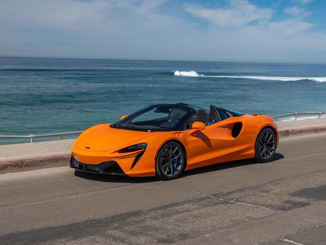 McLaren Artura Spider orange, trois quarts avant en bord de mer