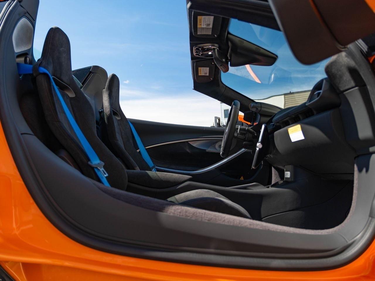 McLaren Artura Spider, sièges baquet et ceintures bleues, portière ouverte